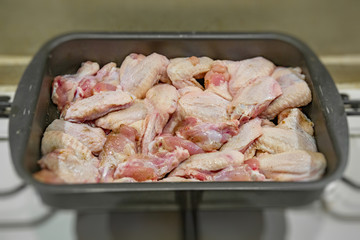 Fresh appetizing chicken wings fried on a kitchen gas stove