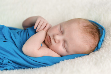 A small newborn girl in a blue diaper is sleeping. Sweet dream. Close-up