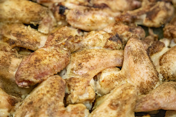 Fresh appetizing chicken wings fried on a kitchen gas stove