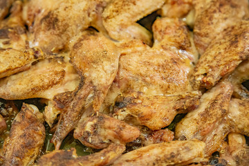 Fresh appetizing chicken wings fried on a kitchen gas stove