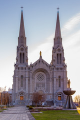 Fototapeta na wymiar Vertical early morning view of the 1926 roman catholic Beaux-Arts style Basilica of Sainte-Anne-de-Beaupré along the St. Lawrence River, Quebec, Canada