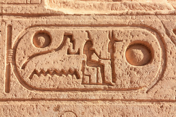 Ancient rock-cut hyroglyphs in southern Egypt in Abu Simbel. A close-up in the sunshine. The temple is located on a large reservoir. The word surround is called Cartouche. - obrazy, fototapety, plakaty