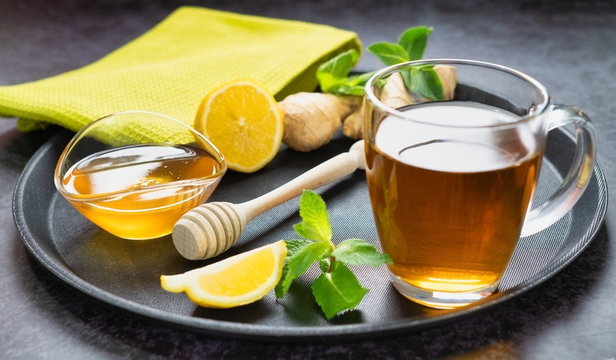 A cup of tea with honey and lemon image