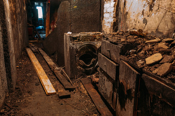Burnt house interior. Burned burnt bathroom, Fused remains of furniture and washing machine