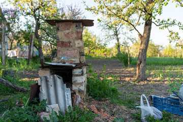 Outdoor brick stove among the garden in the village