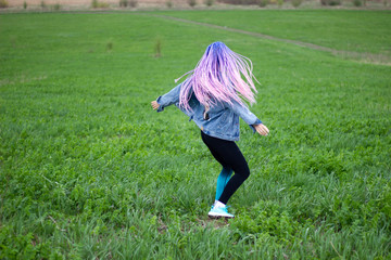 girl with dreadlocks on a green field
