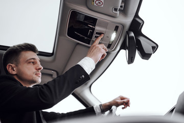 Handsome serious man is renting modern automobile
