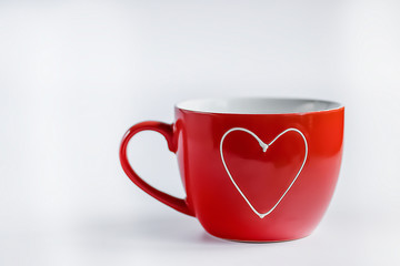 Red cup with white heart on  white background. Soft focus.