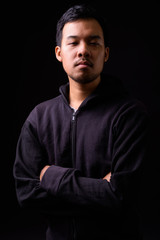 Portrait of young Asian man wearing hoodie with arms crossed