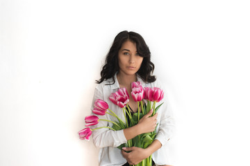 A portrait of beautiful young woman with pink tulips.