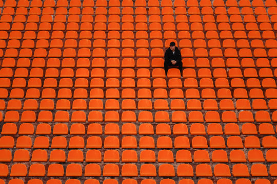 lonely man on the empty stadium seat cheering for the team,the concept of loneliness.