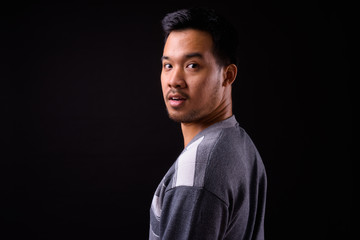 Rear view of young Asian man looking at camera