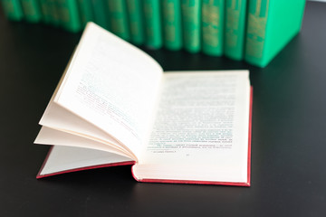 Open book on the background of other books