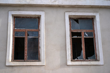 Fototapeta na wymiar Broken glass in the windows of an old house