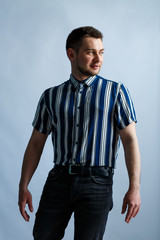 Young man in a striped classic shirt on a white background. Stylish guy dressed in casual style. Male image for every day