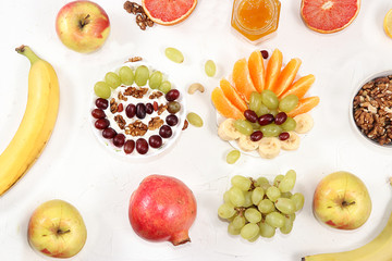 Healthy breakfast, food for children, yogurt with granola, oranges, banana and grapes on a light table. The concept of healthy and natural food, lifestyle. selective focus