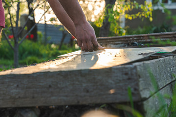 Male farmer hands in a soil, work in the garden, spring sunny day