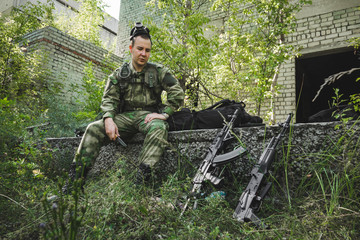 a soldier in a camouflage suit paused to rest