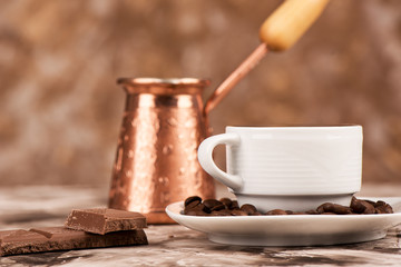 Close up. Full cup of black coffee, coffee beans, chocolate and cezve.