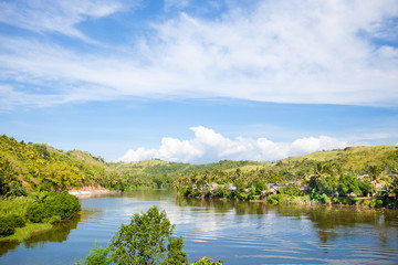 Countryside on a large tropical island. Small village on the green hills by the river. Tropical landscape in sunny weather. Village by the river. The nature of the Philippines, Samar