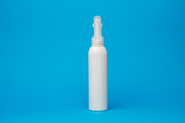 white bottle with cream, hair shampoo, shower gel, isolated blue background, human body beauty
