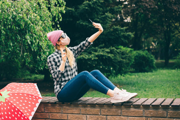 Beautiful woman wearing protective mask taking selfie in the park