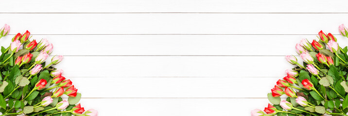 Holiday banner. Red and pink roses bouquet on white wooden background. Mother's day, Valentines Day, Birthday celebration concept. Copy space, top view