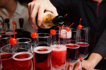 The waiter pours champagne.