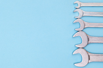 Tools worker, many wrenchs on a blue background, top view with free space