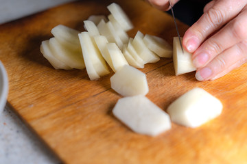 Fototapeta na wymiar Cutting potatoes on a cutting board