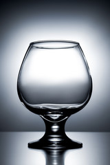 vertical photo empty clean transparent with glares glass for cognac on gray white background with gradient