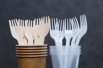 Fototapeta na wymiar Eco-friendly disposable tableware made of bamboo wood and paper on a gray background. Plastic dishes and cutlery. Caring for the environment. Recycling problem. safe planet, environmental concept.