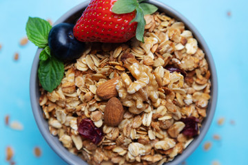Close-up on granola, granola with fresh strawberries, blueberries and nuts. Proper nutrition, diet. Granola home do-it-yourself