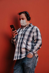 the masked man uses the phone leaning against the wall