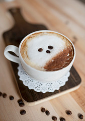 A cup of cappuccino with coffee beans 