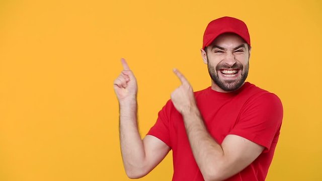 Delivery young guy man in red cap blank t-shirt uniform workwear pointing hands on workspace isolated on yellow background studio Professional male deliveryman employee working courier Service concept