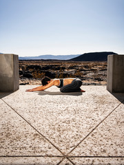 A woman does yoga at a lava field near Amboy Crater