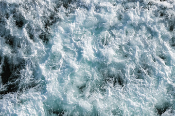 Fototapeta na wymiar Ocean water abstract background. Sea bubbling water texture closeup