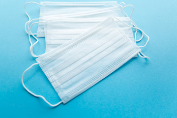 White protective medical mask on a blue background close up
