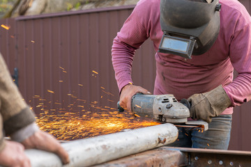 Electric wheel grinding on steel structure in factory