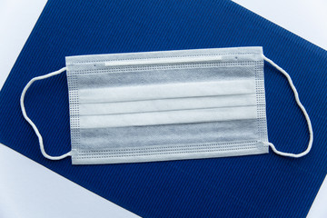 one white protective mask on a dark blue background  close-up. Personal protective equipment