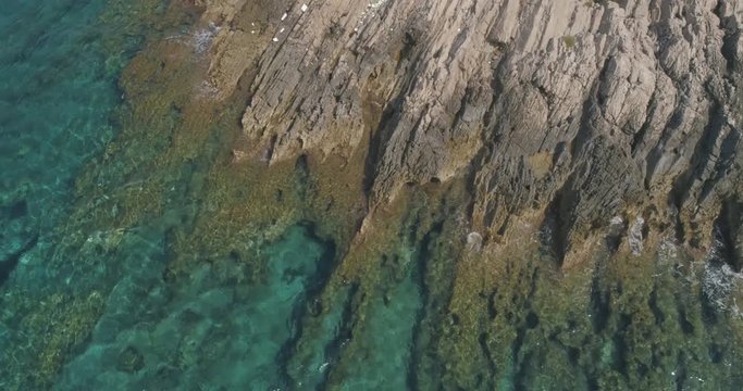 Rocks and sea aerial shot. View from the top of the sea and rocks. Ocean, rocks, parallel to the earth, waves, proora water, coastline.
