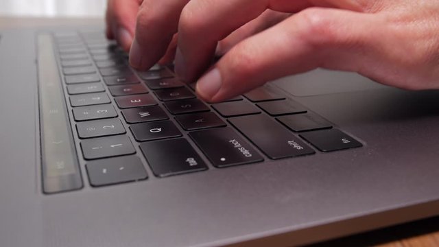 Close-up of fingers typing on the keyboard of a laptop