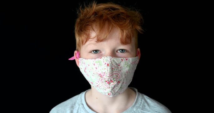 Portrait close up of Little red hair boy wearing face mask during coronavirus epidemic pandemic blue eyes aryan