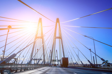 Cable-stayed bridge on a sunny day. Road for cars through the railway. Travelling by car. City business trips. Traffic on the roads.