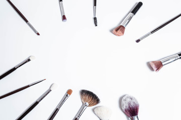 Flat top view a set of professional makeup brushes on a light background. Copy space for your text. Make-up brushe over white background. Aerial view of various brushes. Various makeup brush sizes.