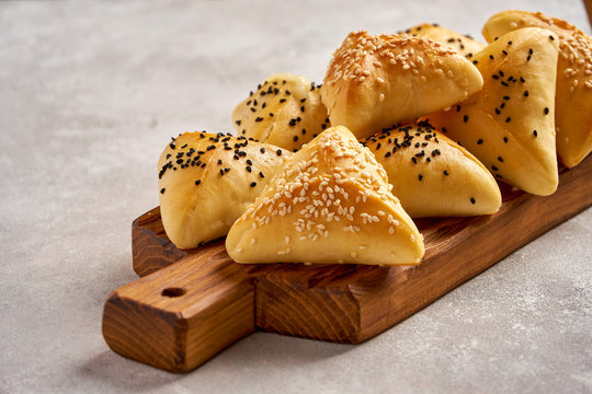 Fatayer samosa with white cheese and black sesame seeds on wooden board. Close up