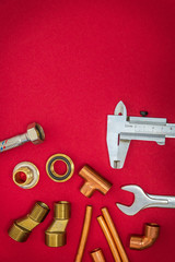 Set of tools and spare parts for plumbing on red background with space for advertising