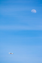 White plane with blue details of the company Air Europa airlines flying with a blue sky and moon in the background