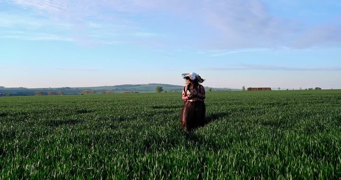 Elegant woman with large hat walking in field opening pandoras box